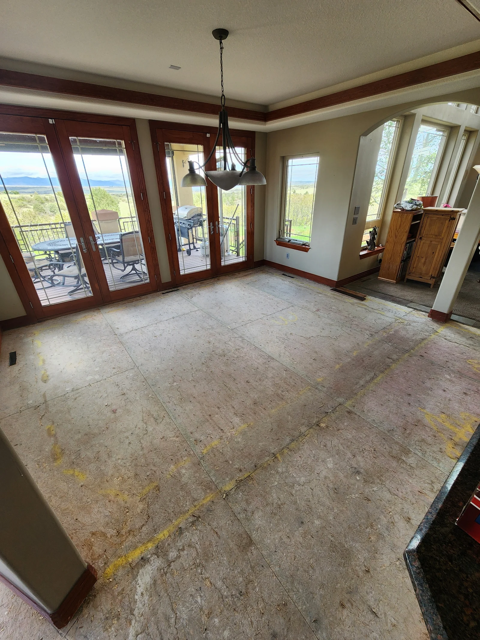 Interior room with painted walls, ceiling, and burgundy wood trim around glass doors and windows