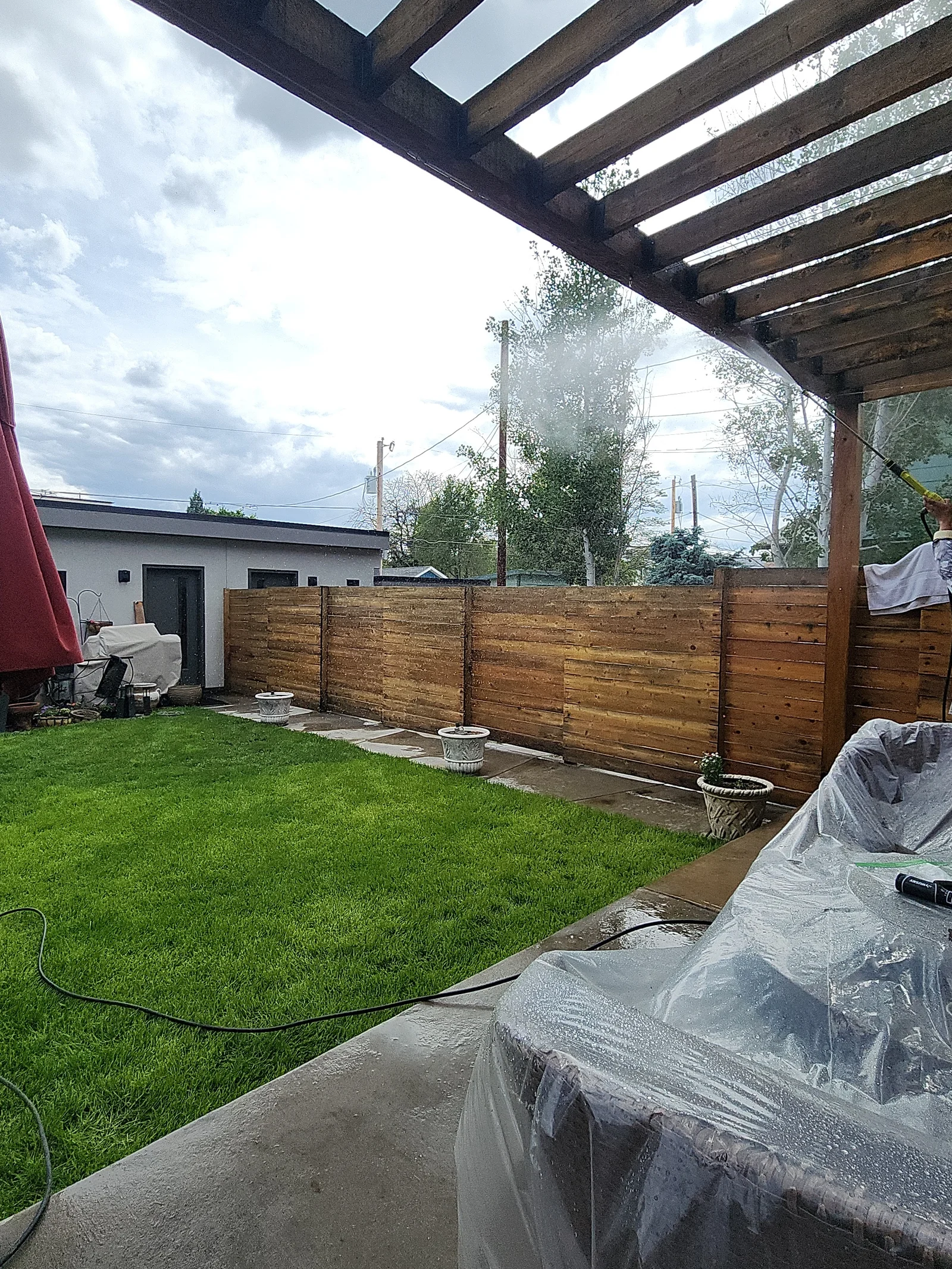 Horizontal wood fence with stained cedar boards and metal posts in residential backyard