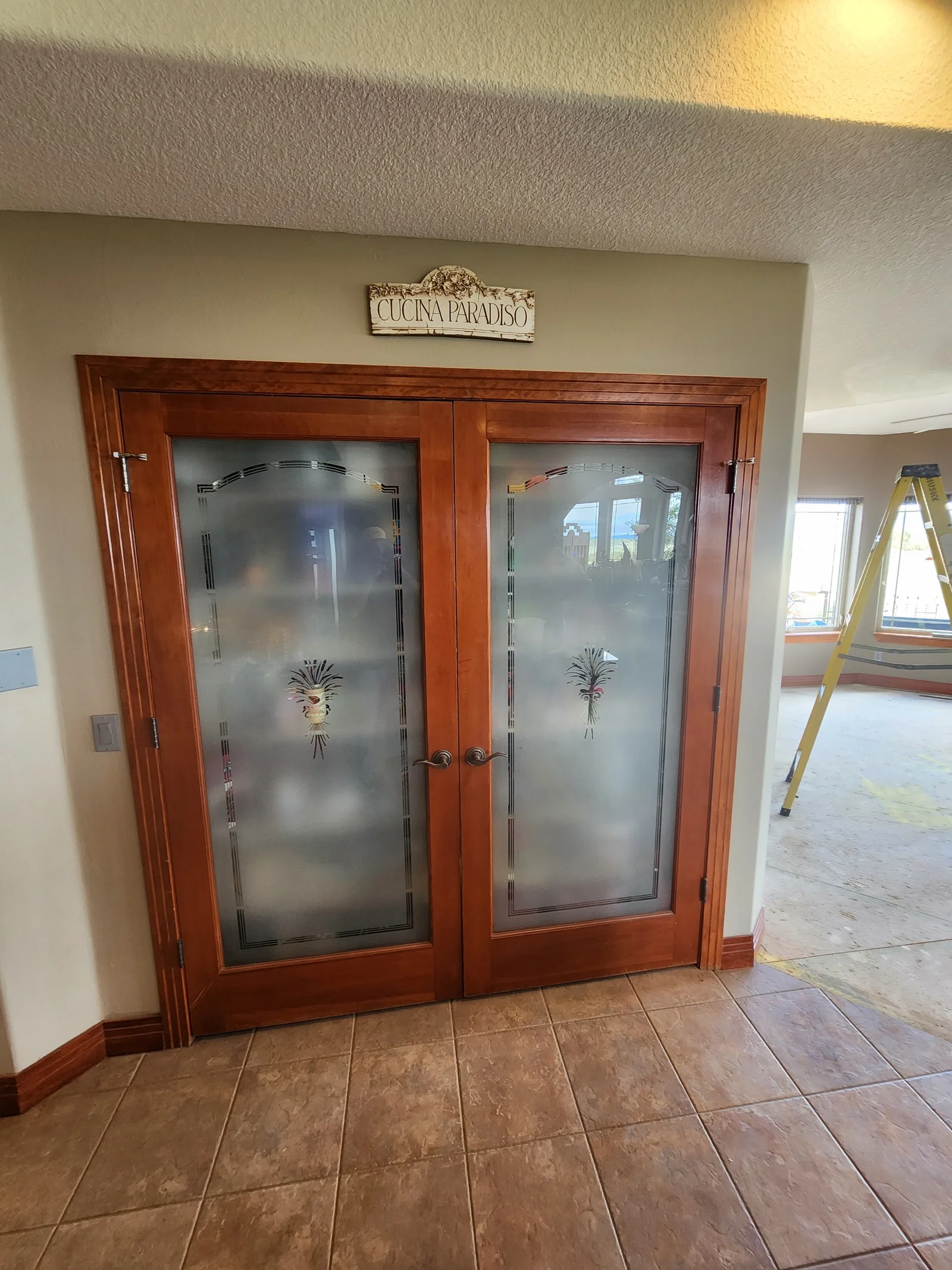 Double glass doors with frosted etched pineapple design in wood frames