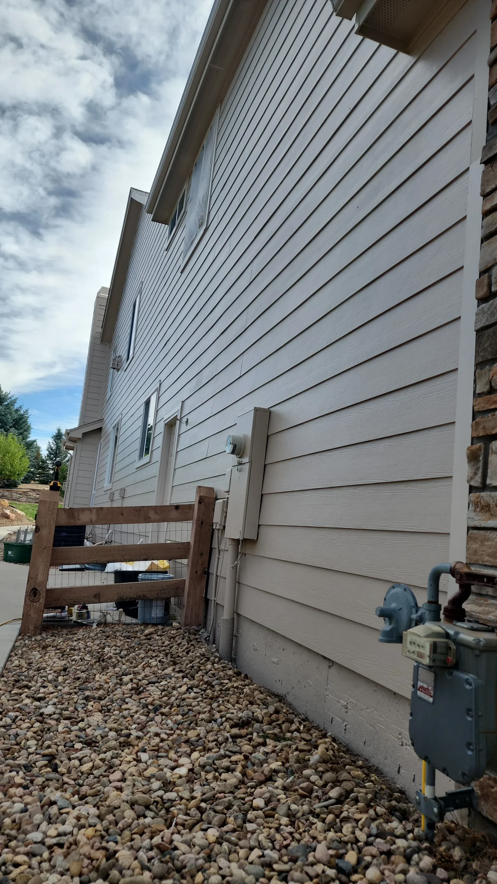 Exterior staining and surface prep completed on a residential home in Aurora, CO, showing even finish and clean trim lines